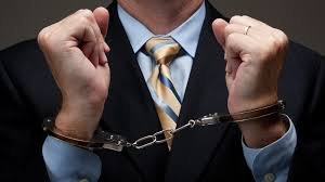 Handcuffed man in business suit expressing frustration, emphasizing privacy concerns and legal issues.