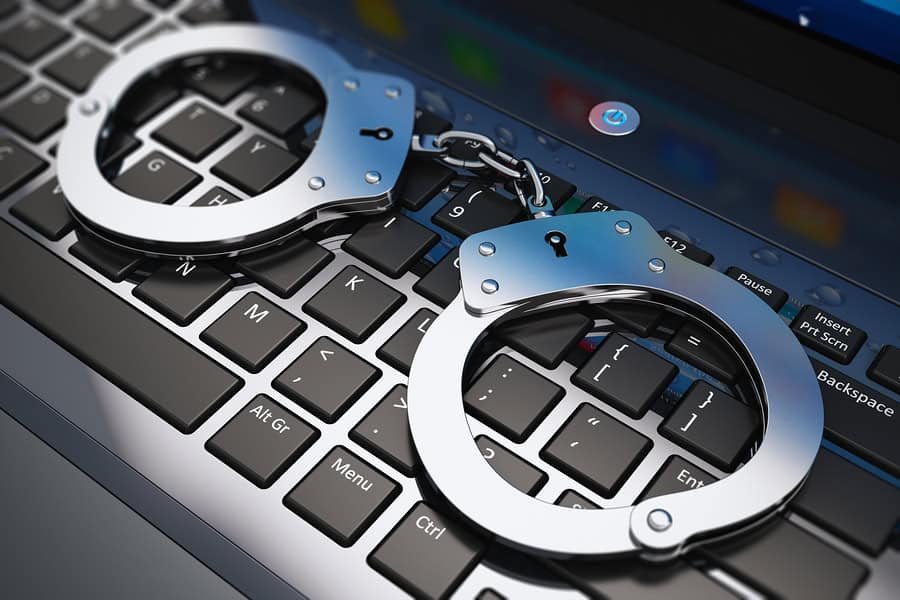 California Self Defense laws and legal principles with handcuffs on laptop representing criminal defense and legal protection